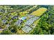Aerial view of the pool, parking, and tennis courts surrounded by green trees and the golf course at 2314 Hummingbird Ln, Summerville, SC 29483