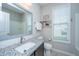 Well-lit bathroom featuring a granite countertop, a decorative mirror, and a toilet near the window at 2314 Hummingbird Ln, Summerville, SC 29483