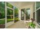 Inviting screened porch with wicker seating, offering a relaxing space with views of the lush backyard and natural light at 2314 Hummingbird Ln, Summerville, SC 29483