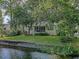 Back exterior of a home with a screened porch overlooking the water and beautiful yard at 2525 Bent Tree Ln, Mount Pleasant, SC 29464