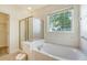 Bathroom with bathtub and glass enclosed shower next to a window at 2525 Bent Tree Ln, Mount Pleasant, SC 29464