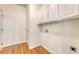 Laundry room with hardwood floors, white walls, and storage cabinets at 2525 Bent Tree Ln, Mount Pleasant, SC 29464