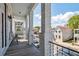 Balcony with white brick columns and black iron railings offers neighborhood views on a sunny day at 272 Coming St # C, Charleston, SC 29403