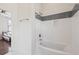 Bathroom featuring a white tiled tub with a stylish gray accent and brass fixtures at 272 Coming St # C, Charleston, SC 29403