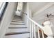 Bright staircase with white railings and wooden steps leading into a living area with ceiling fan at 272 Coming St # C, Charleston, SC 29403