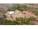 Aerial view of a house, pond, and property surrounded by green and red trees at 280 Royalegates Ct, Cross, SC 29436