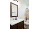 Bathroom vanity with a dark wood finish, white countertops, and a framed mirror, plus a tiled shower at 2836 Edenborough Rd, Johns Island, SC 29455