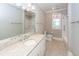 Bathroom featuring a large mirror, shower with white tile and granite counters at 287 Commonwealth Rd, Mount Pleasant, SC 29466
