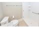 Bathroom with a toilet, towel racks, and a white tile shower featuring grab bars for accessibility at 287 Commonwealth Rd, Mount Pleasant, SC 29466