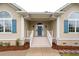 Inviting front entrance with a blue door, white railings, and well-maintained landscaping at 287 Commonwealth Rd, Mount Pleasant, SC 29466