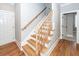 Wooden staircase with hardwood floors and white trim, ascending to the next level and showing natural light at 287 Commonwealth Rd, Mount Pleasant, SC 29466