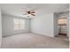 Bright bedroom with neutral walls, carpet, a ceiling fan, and window and doorway to a laundry room at 296 Torslanda Ln, Summerville, SC 29486