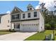 Beautiful two-story home with neutral siding, manicured lawn, and attached two car garage at 296 Torslanda Ln, Summerville, SC 29486