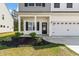 Inviting two-story home featuring a covered porch, well-maintained landscaping, and an attached two-car garage at 296 Torslanda Ln, Summerville, SC 29486