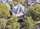 Aerial view of a stunning home featuring a metal roof and inviting front porch nestled among lush trees at 300 Ginned Cotton St, Charleston, SC 29492