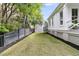 Spacious backyard featuring lush green lawn with a dark fence for privacy and manicured landscaping at 300 Ginned Cotton St, Charleston, SC 29492