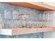 Cozy bar area with beautiful glassware on floating wood shelves and pretty blue tile at 300 Ginned Cotton St, Charleston, SC 29492