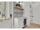Elegant bar area with a wine fridge, open shelving, and soft, natural lighting at 300 Ginned Cotton St, Charleston, SC 29492