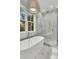 This modern bathroom features a spacious walk-in shower and a luxurious soaking tub, creating a relaxing atmosphere at 300 Ginned Cotton St, Charleston, SC 29492