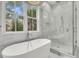 A modern bathroom features a soaking tub, glass shower, and marble accents, creating a luxurious spa-like retreat at 300 Ginned Cotton St, Charleston, SC 29492