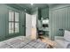 Stylish bedroom with a built-in desk, comfortable chair, and calming green walls and trim at 300 Ginned Cotton St, Charleston, SC 29492