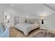 Cozy bedroom with wood floors, soft lighting, and ensuite bathroom access in a modern aesthetic at 300 Ginned Cotton St, Charleston, SC 29492