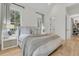 A serene primary bedroom is filled with natural light, complemented by wood floors and cozy decor at 300 Ginned Cotton St, Charleston, SC 29492
