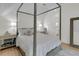 Comfortable bedroom featuring a canopy bed, soft lighting, and ensuite bathroom access at 300 Ginned Cotton St, Charleston, SC 29492