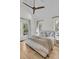 Primary bedroom with light walls, neutral decor, hardwood floors, and abundant natural light at 300 Ginned Cotton St, Charleston, SC 29492
