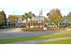 Elegant clubhouse entrance with classic architecture, palm trees, and manicured landscaping at 300 Ginned Cotton St, Charleston, SC 29492