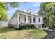 Charming white home with a covered porch, columns, and lush landscaping at 300 Ginned Cotton St, Charleston, SC 29492