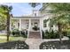 Inviting two-story home features a charming front porch, beautiful landscaping, and a brick walkway leading to the front door at 300 Ginned Cotton St, Charleston, SC 29492
