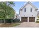 Exterior featuring a detached garage with wooden doors and brick driveway surrounded by lush trees at 300 Ginned Cotton St, Charleston, SC 29492