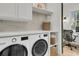 Well-organized laundry room with modern washer and dryer, shelving, and adjacent office space at 300 Ginned Cotton St, Charleston, SC 29492