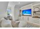 Inviting living space with custom built-ins, beach views on TV, and comfortable seating arrangement at 300 Ginned Cotton St, Charleston, SC 29492