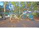 Colorful playground with slides, swings, and climbing structures set in a wooded area at 300 Ginned Cotton St, Charleston, SC 29492
