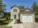 Charming two-story home featuring green shutters, a bright green door, a lush lawn, and a one-car garage at 319 Parish Park, Summerville, SC 29485