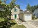 Charming two-story home featuring green shutters, a bright green door, a lush lawn, and a one-car garage at 319 Parish Park, Summerville, SC 29485