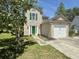 Charming two-story home featuring green shutters, a bright green door, a lush lawn, and a one-car garage at 319 Parish Park, Summerville, SC 29485