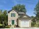Charming two-story home featuring green shutters, a bright green door, a lush lawn, and a one-car garage at 319 Parish Park, Summerville, SC 29485