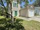Charming two-story home featuring green shutters, a bright green door, a lush lawn, and a one-car garage at 319 Parish Park, Summerville, SC 29485