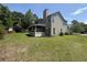 Rear view of home highlighting spacious green backyard, screened-in porch, and mature trees at 319 Parish Park, Summerville, SC 29485