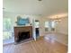 Cozy living room with brick fireplace, large windows, and access to a screened porch, perfect for indoor-outdoor living at 319 Parish Park, Summerville, SC 29485
