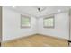 Bright bedroom with modern ceiling fan, two windows, and light wood flooring at 32 Elmora Ave, Goose Creek, SC 29445