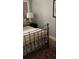 Cozy bedroom with a cast iron bed frame, wood floors, and a bedside table with a lamp at 330 Concord St # Th17, Charleston, SC 29401