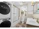 Well-lit bathroom boasts stackable washer and dryer, white subway tiles, and double vanity at 35 Society St # D, Charleston, SC 29401