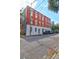 Brick multifamily home on city street, with a bright blue sky and several parked vehicles at 35 Society St # D, Charleston, SC 29401