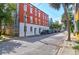 Brick multifamily home on city street, with a bright blue sky and several parked vehicles at 35 Society St # D, Charleston, SC 29401