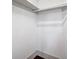 Bright, small walk-in closet with white walls, shelving supports and a wooden bar at 35 Society St # D, Charleston, SC 29401