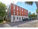 Three-story brick building with white trim and several windows, street view with parked cars at 35 Society St # D, Charleston, SC 29401